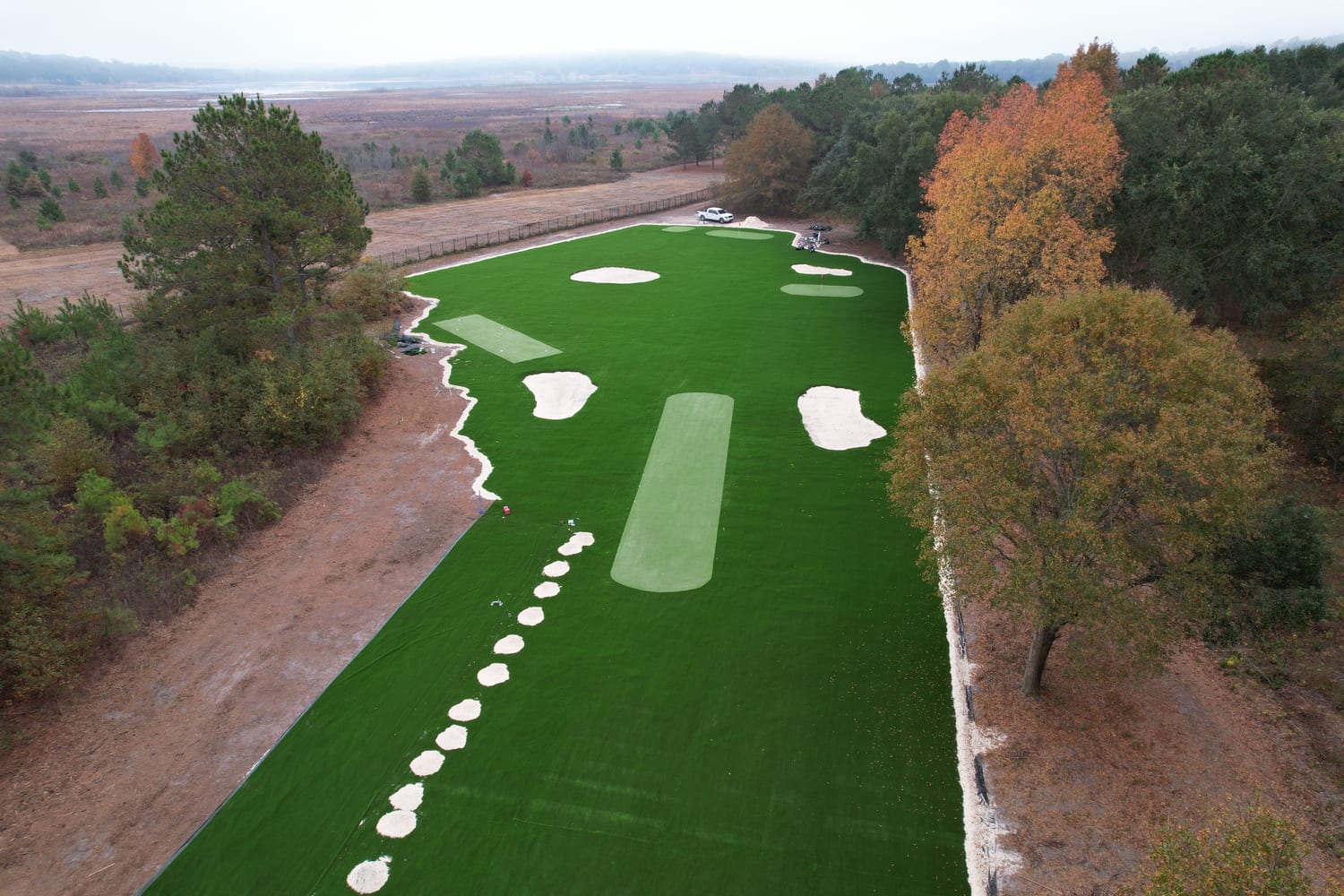 Aerial view of a custom artificial putting green with sand bunkers